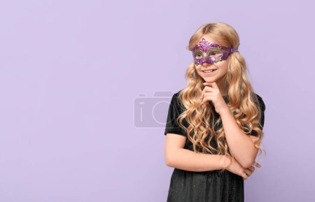 Photo for Cute little girl wearing carnival mask on lilac background - Royalty Free Image