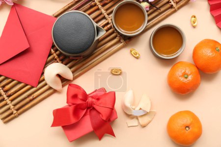 Photo for Gift box with fortune cookies, mandarins and cups of tea on beige background. New Year celebration - Royalty Free Image
