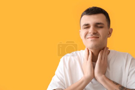 Hombre joven con problema de la glándula tiroides sobre fondo amarillo