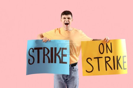 Photo for Protesting young man with placards on pink background. Strike concept - Royalty Free Image