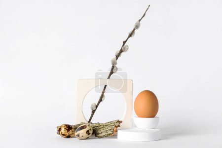 Dekorative Podeste mit Ostereiern, Weidenzweig und Baumrinde auf weißem Hintergrund