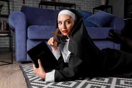 Sexy Nonne mit Kreuz und Bibel liegt zu Hause auf dem Boden