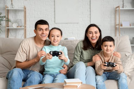 Photo for Happy family playing video game on sofa at home - Royalty Free Image
