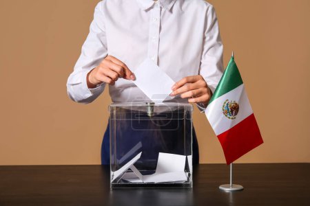 Voting young woman with Mexican flag near ballot box on brown background, closeup