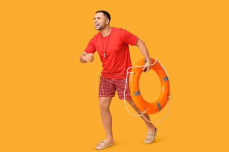 Glücklicher junger Bademeister mit Rettungsring, der auf gelbem Hintergrund läuft