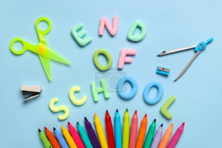 Text END OF SCHOOL, scissors and colorful felt-tip pens on blue background. Top view
