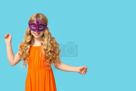 Photo for Little girl wearing carnival mask on blue background - Royalty Free Image