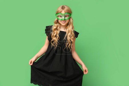Photo for Cute little girl wearing carnival mask on green background - Royalty Free Image