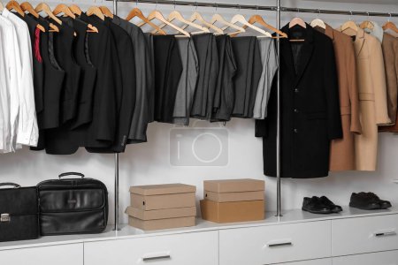 Photo for Rack with clothes and shoes in modern man's wardrobe - Royalty Free Image
