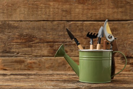Photo for Watering can with gardening tools on wooden background - Royalty Free Image