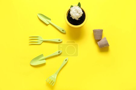 Téléchargez les photos : Fournitures de jardinage et jacinthe en pot sur fond jaune - en image libre de droit