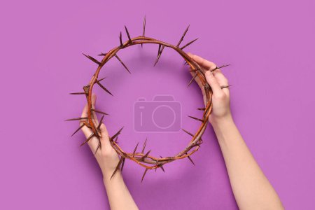 Photo for Female hands with crown of thorns on purple background. Good Friday concept - Royalty Free Image