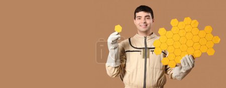 Male beekeeper with paper honeycombs on brown background with space for text