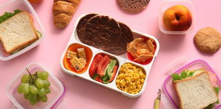 Foto de Almuerzos con diferentes sabrosos alimentos sobre fondo rosa - Imagen libre de derechos