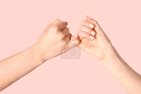 Photo for Hands of friends making pinky promise on color background - Royalty Free Image