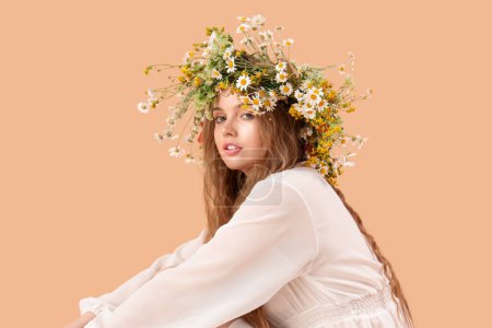 Téléchargez les photos : Belle jeune femme en couronne de fleurs sur fond beige. Solstice d'été - en image libre de droit