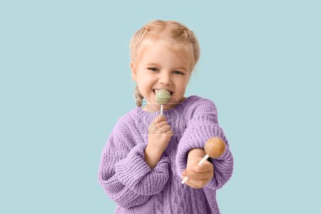 Foto de Linda niña con piruletas dulces sobre fondo azul - Imagen libre de derechos
