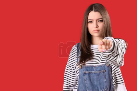 Photo for Young woman pointing at viewer on red background. Accusation concept - Royalty Free Image