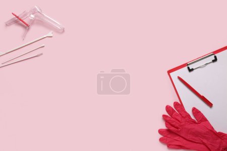 Klemmbrett mit medizinischen Handschuhen, gynäkologischem Spekulum und Pap-Abstrichprüfgeräten auf rosa Hintergrund