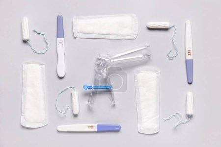 Téléchargez les photos : Speculum gynécologique avec tampons, tampons et tests de grossesse sur fond blanc - en image libre de droit