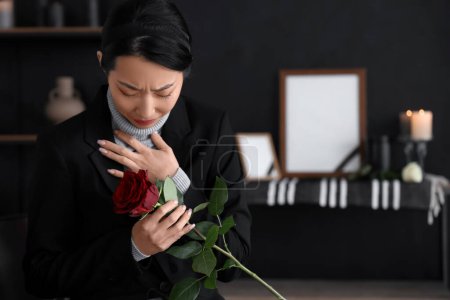 deuil jeune asiatique femme avec rose à funérailles