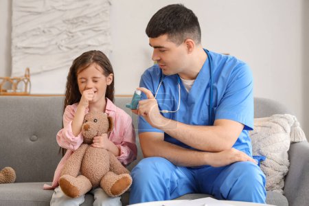 Médico varón dando inhalador a una niña tosiendo en casa