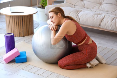 Deportiva mujer madura con fitball experimentar la menopausia en casa
