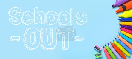 Marqueurs et texte SCHOOLS OUT sur fond bleu clair