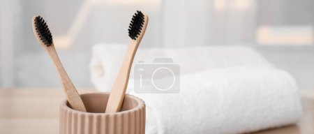 Téléchargez les photos : Support avec brosses à dents en bambou dans la salle de bain, gros plan. Bannière pour le design - en image libre de droit