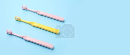 Téléchargez les photos : Brosses à dents en plastique sur fond bleu clair avec espace pour le texte - en image libre de droit