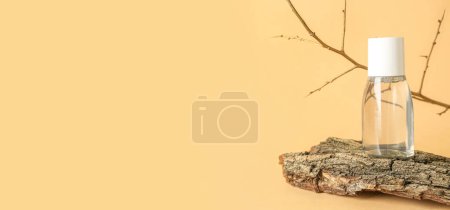 Foto de Botella de agua micelar con rama de árbol y corteza sobre fondo amarillo con espacio para texto - Imagen libre de derechos