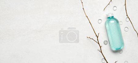 Foto de Botella de agua micelar con ramas de árbol sobre fondo claro con espacio para texto - Imagen libre de derechos