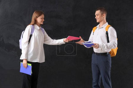 Photo for Students with copybooks and backpacks on blackboard background. End of school concept - Royalty Free Image