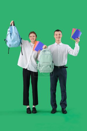 Photo for Students with copybooks and backpacks on green background. End of school concept - Royalty Free Image