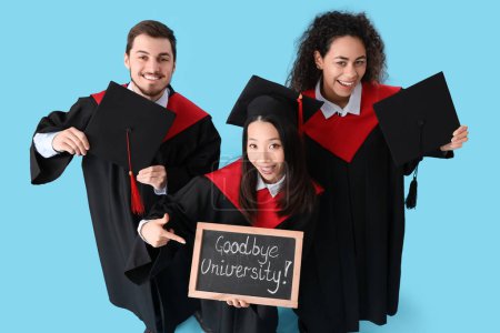 Photo for Graduate students holding chalkboard with text GOODBYE UNIVERSITY on blue background - Royalty Free Image