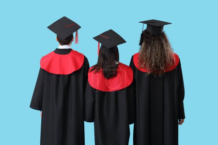 Photo for Graduate students walking away on blue background, back view - Royalty Free Image