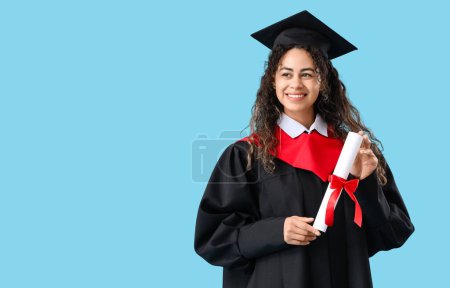 Photo for African-American female graduate student with diploma on blue background - Royalty Free Image