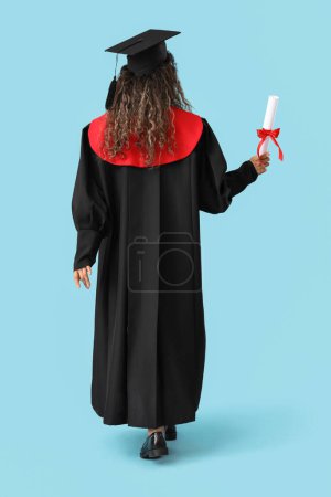Photo for Female graduate student with diploma on blue background, back view - Royalty Free Image