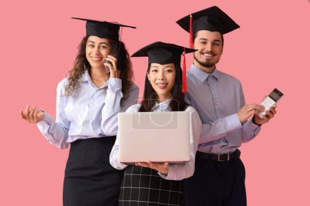 Photo for Graduate students with laptop, calculator and mobile phone on pink background - Royalty Free Image