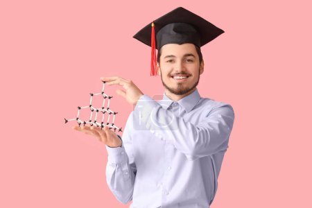 Photo for Male graduate student with molecular model on pink background - Royalty Free Image