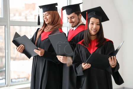 Photo for Graduate students with diplomas in light room - Royalty Free Image