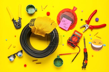 Foto de Composición con suministros de electricista y decoración de fiesta sobre fondo amarillo. Celebración del Día de los Inocentes - Imagen libre de derechos