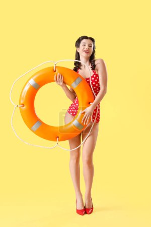 Schöner Pin-up Rettungsschwimmer mit Ringboje auf gelbem Hintergrund