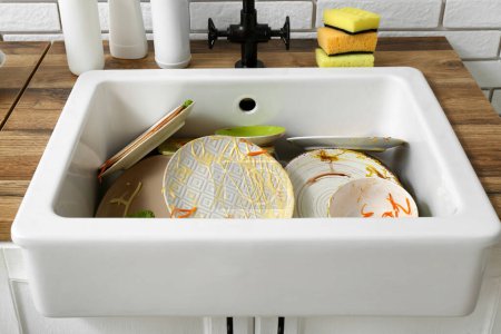 Ceramic sink with dirty dishes in kitchen