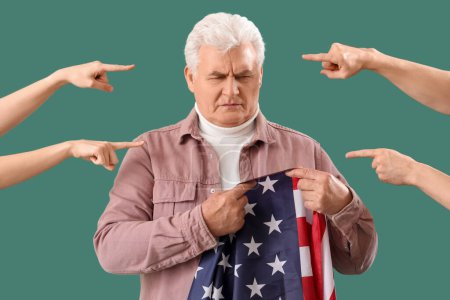 Menschen zeigen auf einen älteren Mann mit USA-Flagge auf grünem Hintergrund. Anschuldigungskonzept