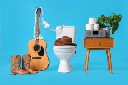 Toilet bowl with cowboy hat, boots and guitar on blue background
