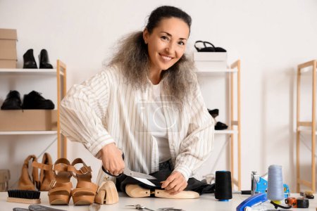 Zapatera mujer cortando tela en taller