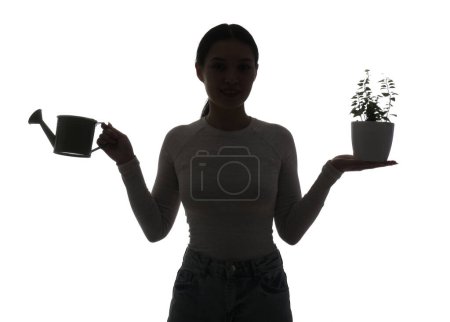 Silhouette of young Asian woman with watering can and plant on white background