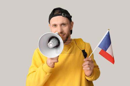 Étudiant mâle avec drapeau de France et mégaphone sur fond clair