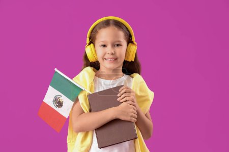 Petite fille en casque avec drapeau mexicain et livre sur fond violet